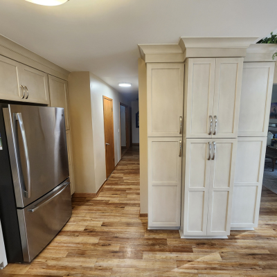 wood-look flooring in a kitchen with stainless steel fridge
